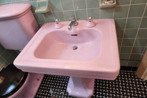 View of pink vintage sink in a renovated bathroom.