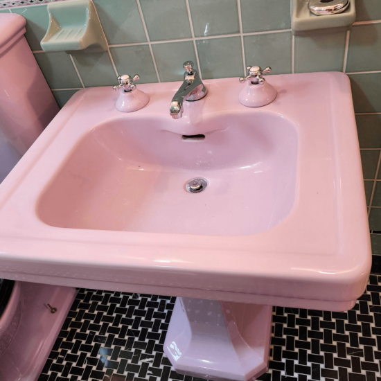 View of pink vintage sink in a renovated bathroom.