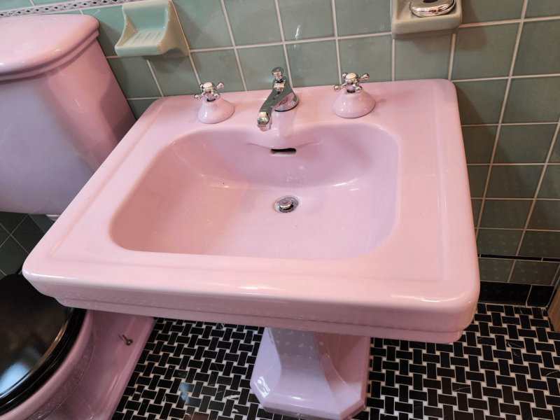 View of pink vintage sink in a renovated bathroom.