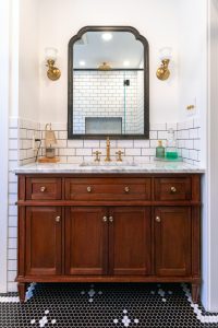 View of a new vanity and mirror in a remodeled bathroom.