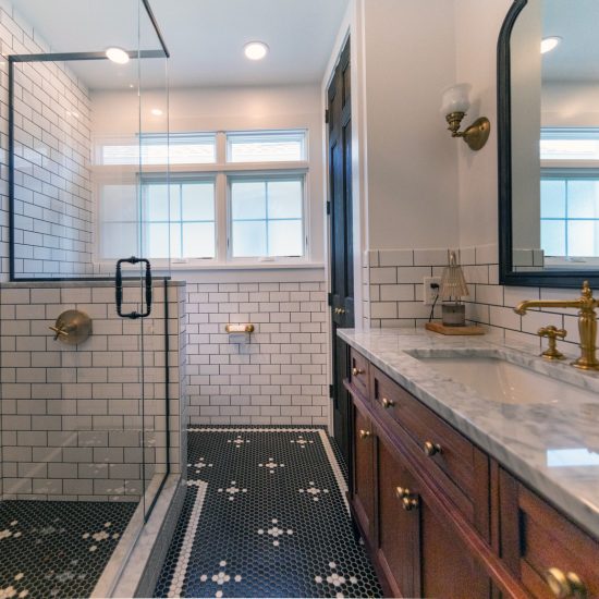 View of a newly remodeled bathroom with black and white tile.