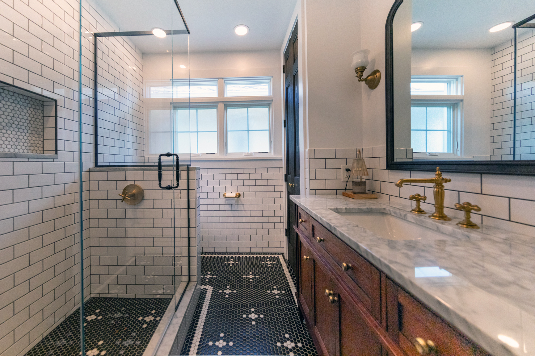 View of a newly remodeled bathroom with black and white tile.