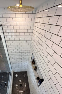 Close up of the shower in a custom tiled black and white bathroom.