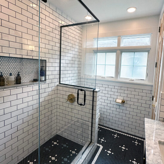 View of a newly remodeled bathroom with black and white tile.
