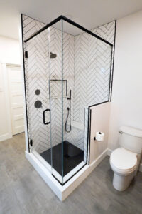 Close up view of the modern black and white tiled shower in a newly remodeled bathroom.