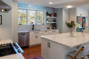 View of a newly remodeled kitchen featuring white cabinetry and white marble countertops.