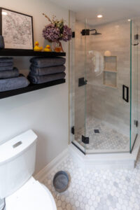 View of custom corner shower and floating shelves in a recently renovated bathroom in Pittsburgh.