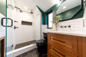 Photo of a bathroom renovation in Pittsburgh that features black and white tile, a walk-in shower, and wood vanity.