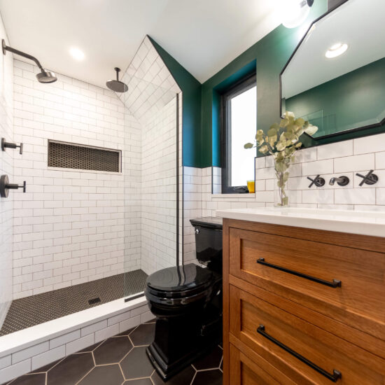 Photo of a bathroom renovation in Pittsburgh that features black and white tile, a walk-in shower, and wood vanity.