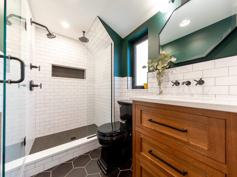 Photo of a bathroom renovation in Pittsburgh that features black and white tile, a walk-in shower, and wood vanity.