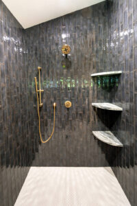 View of the blue tile shower in a remodeled bathroom.