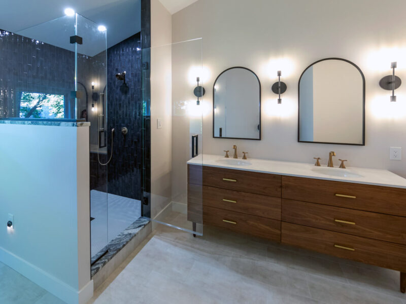 View of a beautifully remodeled bathroom with spacious walk-in shower, gorgeous vanity, and glass tile.