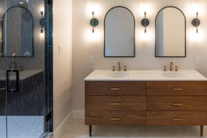 View of modern vanity in a beautifully remodeled bathroom with gold fixtures.