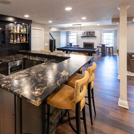 View of a renovated basement with a family room, bar, game room, and bathroom.