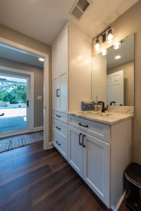 View of the sink in a white bathroom in a remodeled basement.