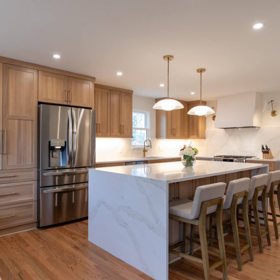 View of a beautiful kitchen renovation in Mt. Lebanon featuring new cabinets and an island with a waterfall countertop.