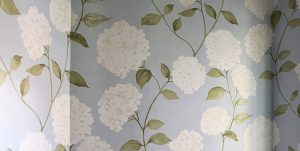 Close up view of the blue floral wallpaper in a recently remodeled powder room.