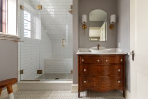View of remodeled master bathroom with wood vanity and walk-in shower.