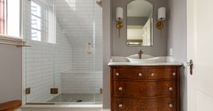 View of remodeled master bathroom with wood vanity and walk-in shower.