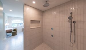 View from within a spa-like custom tiled shower looking out at the vanity area is a spacious master bathroom.