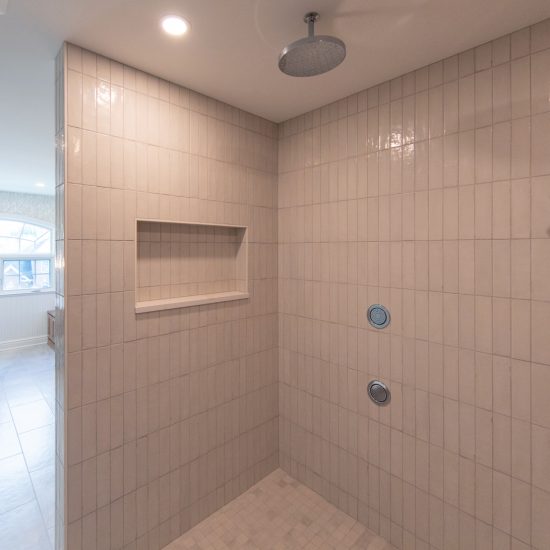View from within a spa-like custom tiled shower looking out at the vanity area is a spacious master bathroom.