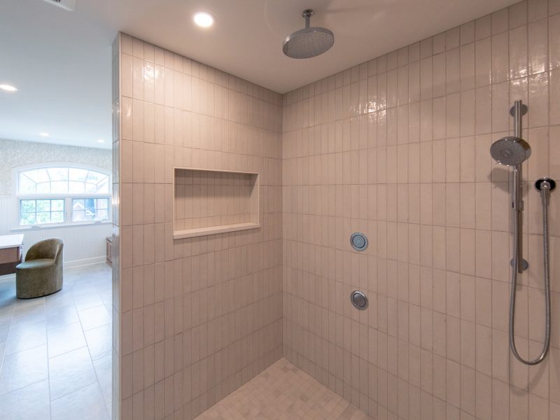 View from within a spa-like custom tiled shower looking out at the vanity area is a spacious master bathroom.