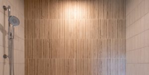 Close up view of the feature wall in a custom tiled shower with light coming from above.