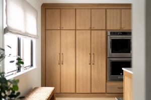 Remodeled kitchen with a large island, warm cabinetry, and black and gold accents.
