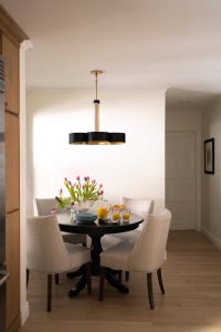 Remodeled kitchen with a large island, warm cabinetry, and black and gold accents.